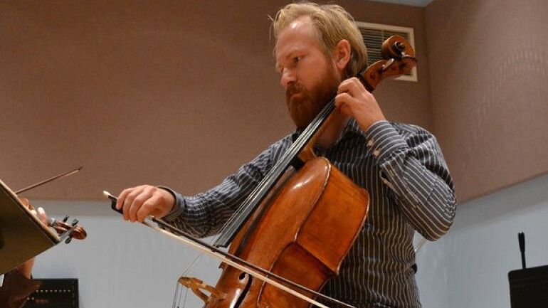 Mannlig violinist med rutete skjorte og lyst hår