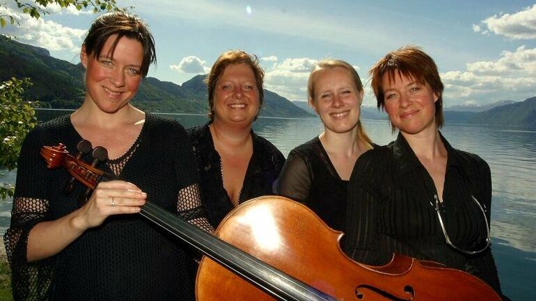 Fire kvinner foran en stor cello
